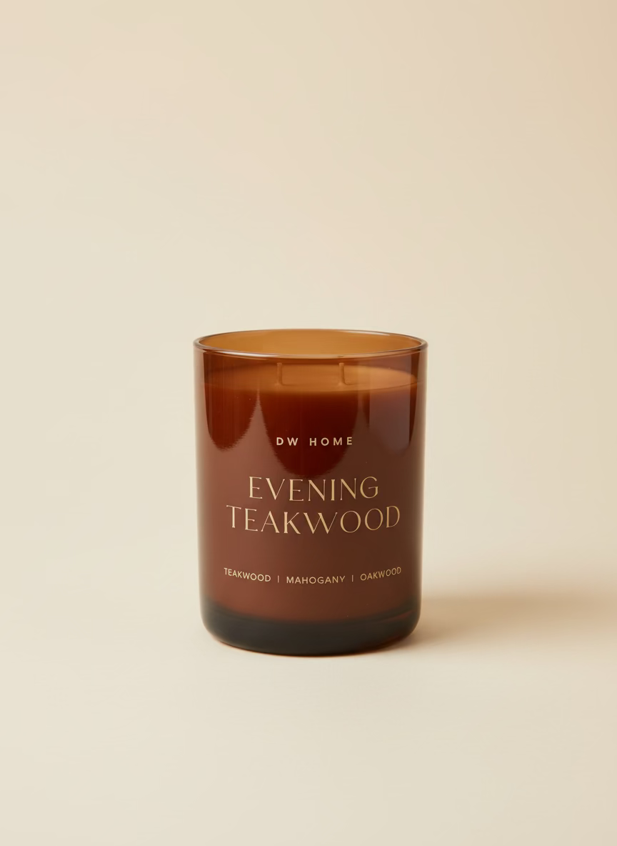 Brown candle labeled 'Evening Teakwood' by DW Home on a beige background