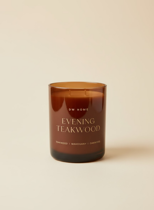 Brown candle labeled 'Evening Teakwood' by DW Home on a beige background